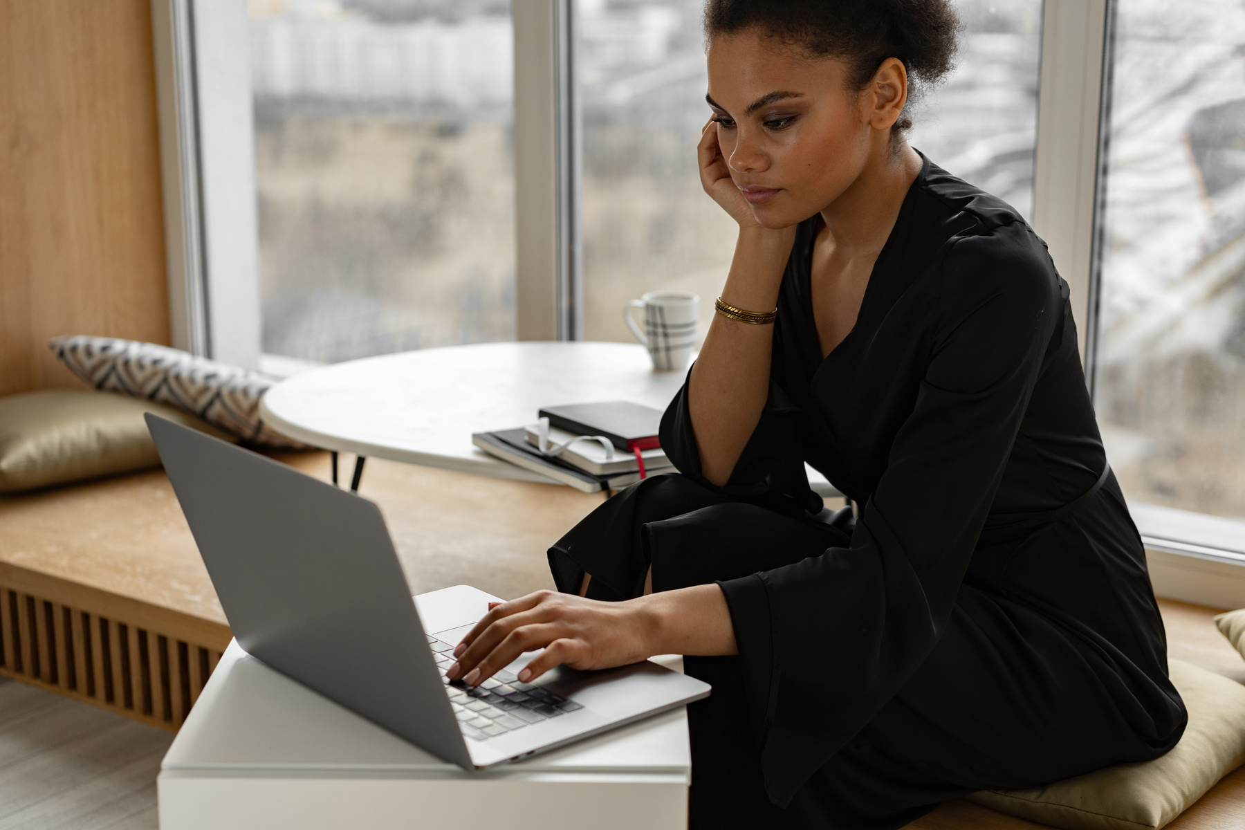 Woman in Black Dress Using a Silver Laptop